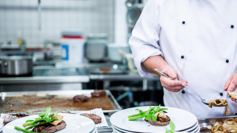 Szef kuchni EAT by Sodexo podczas komponowania dania